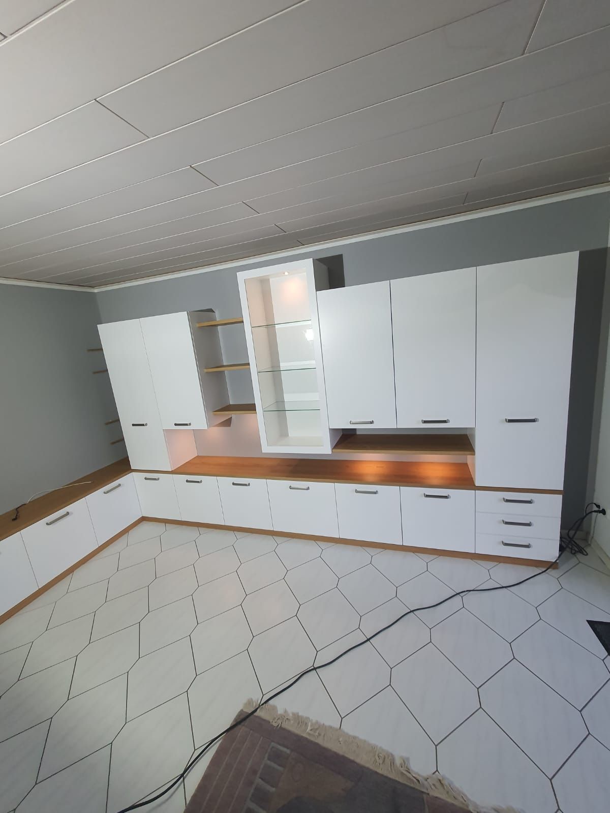 Ein Zimmer mit weißen Schränken und einem Teppich auf dem Boden