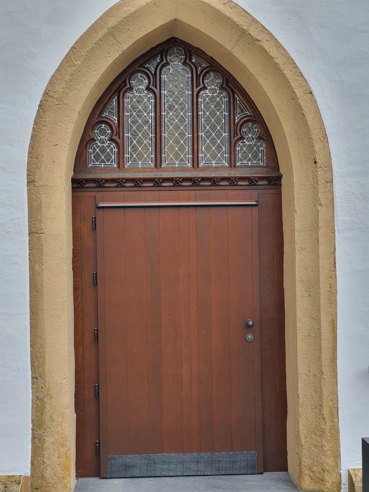 Eine Holztür mit einem Buntglasfenster darüber