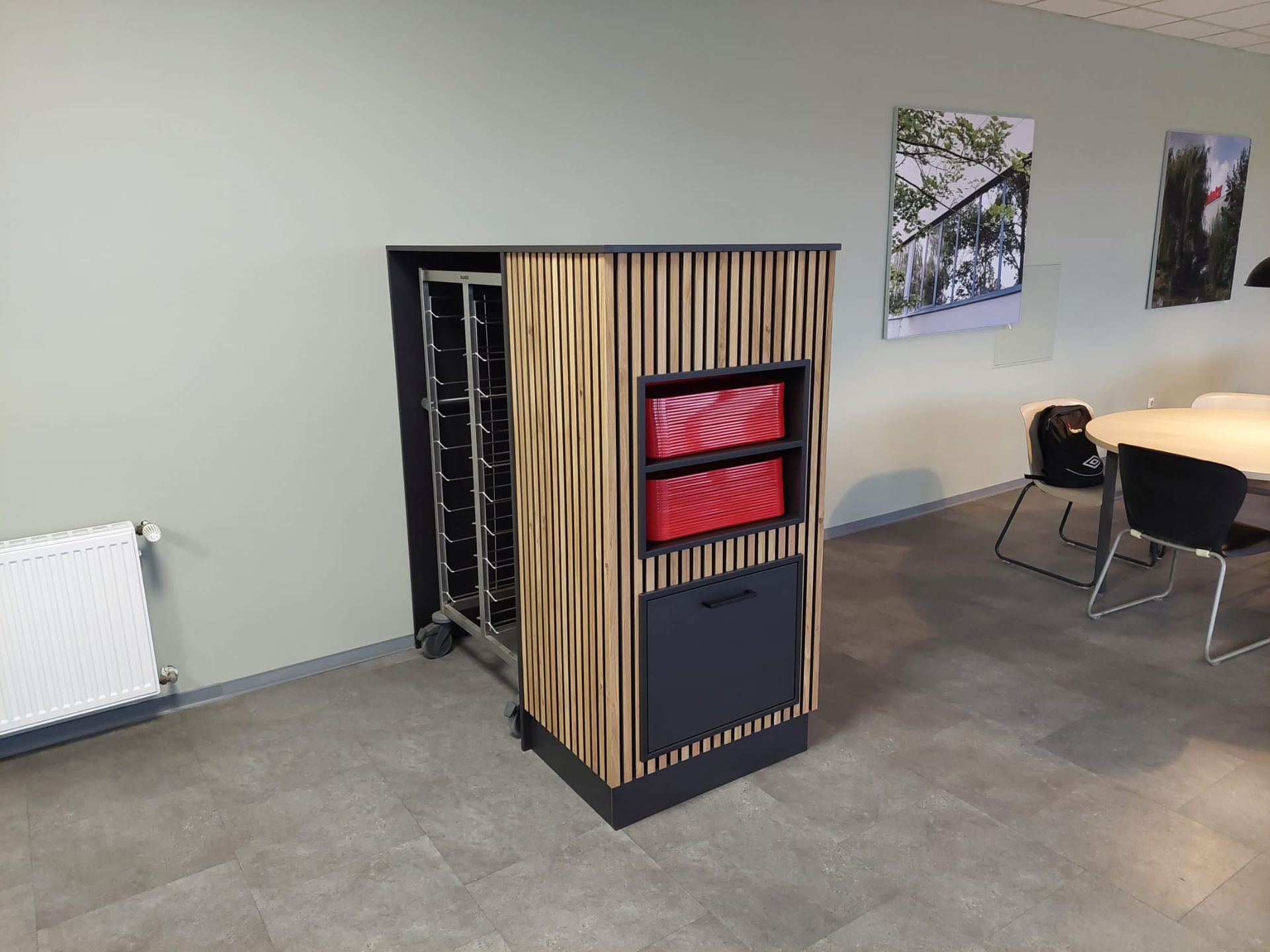 Ein Raum mit einem Tisch und Stühlen und einem Holzschrank.