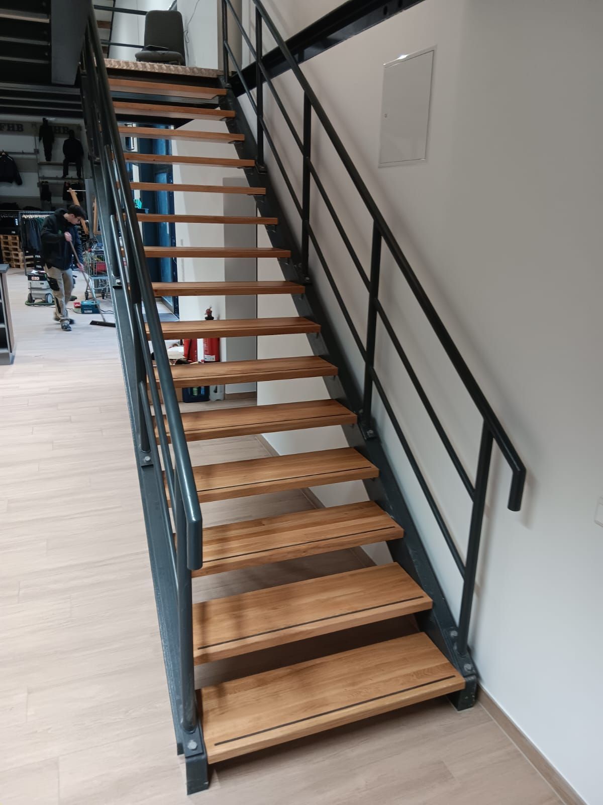 Eine Holztreppe mit einem Metallgeländer in einem Raum