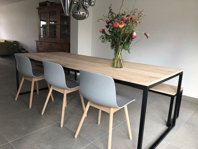 Ein Tisch mit Stühlen und einer Vase mit Blumen darauf