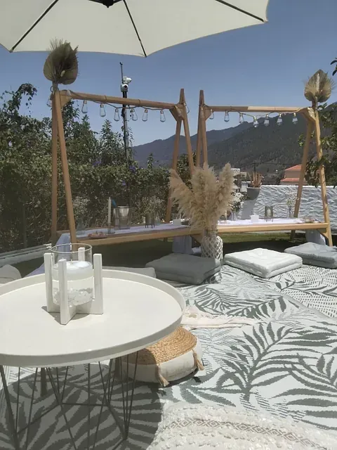 Una mesa con velas se encuentra debajo de una sombrilla.