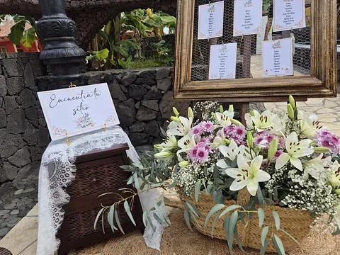 Una cesta de flores está al lado de una caja de madera.