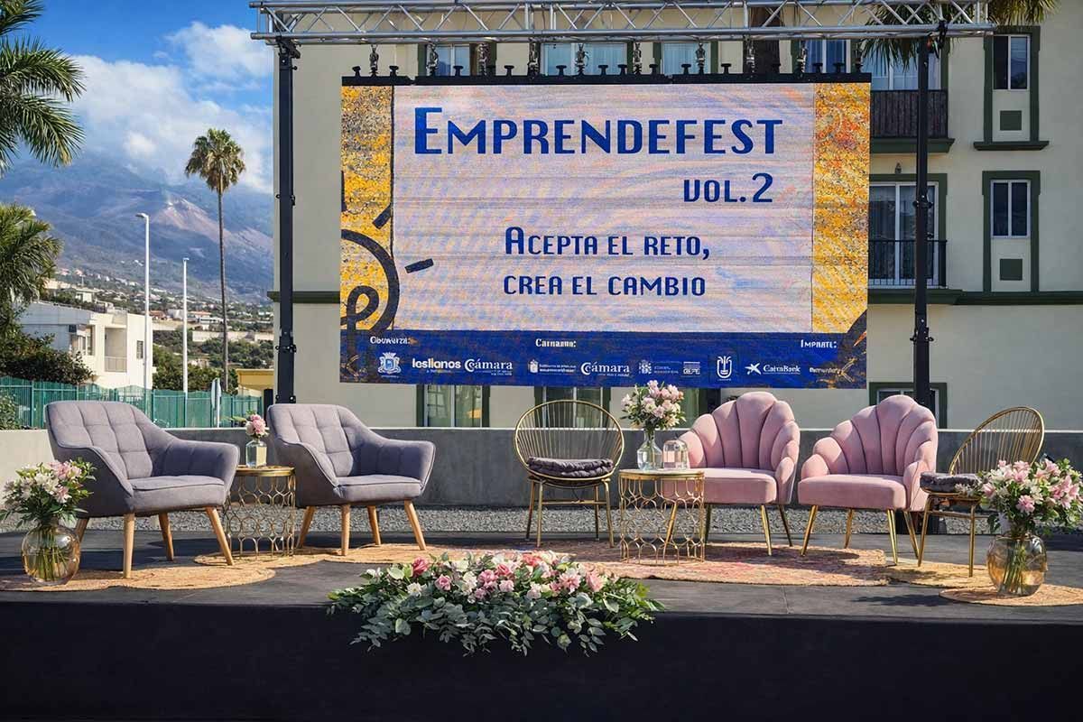 Montaje del escenario para el evento Emprendefest Vol. 2 con sillas, flores y una pantalla que muestra los detalles del evento; fondo montañoso.