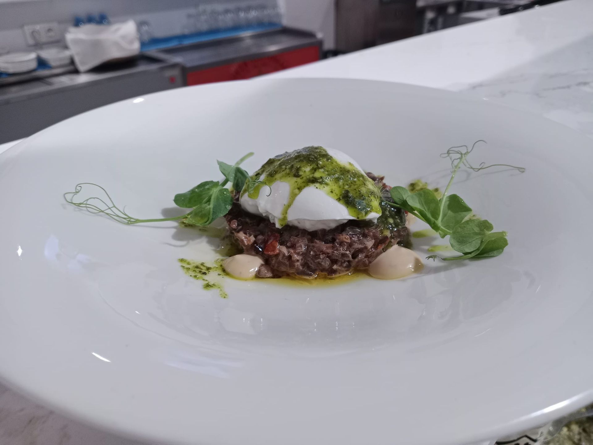 Un plato blanco cubierto con un huevo escalfado y verduras.