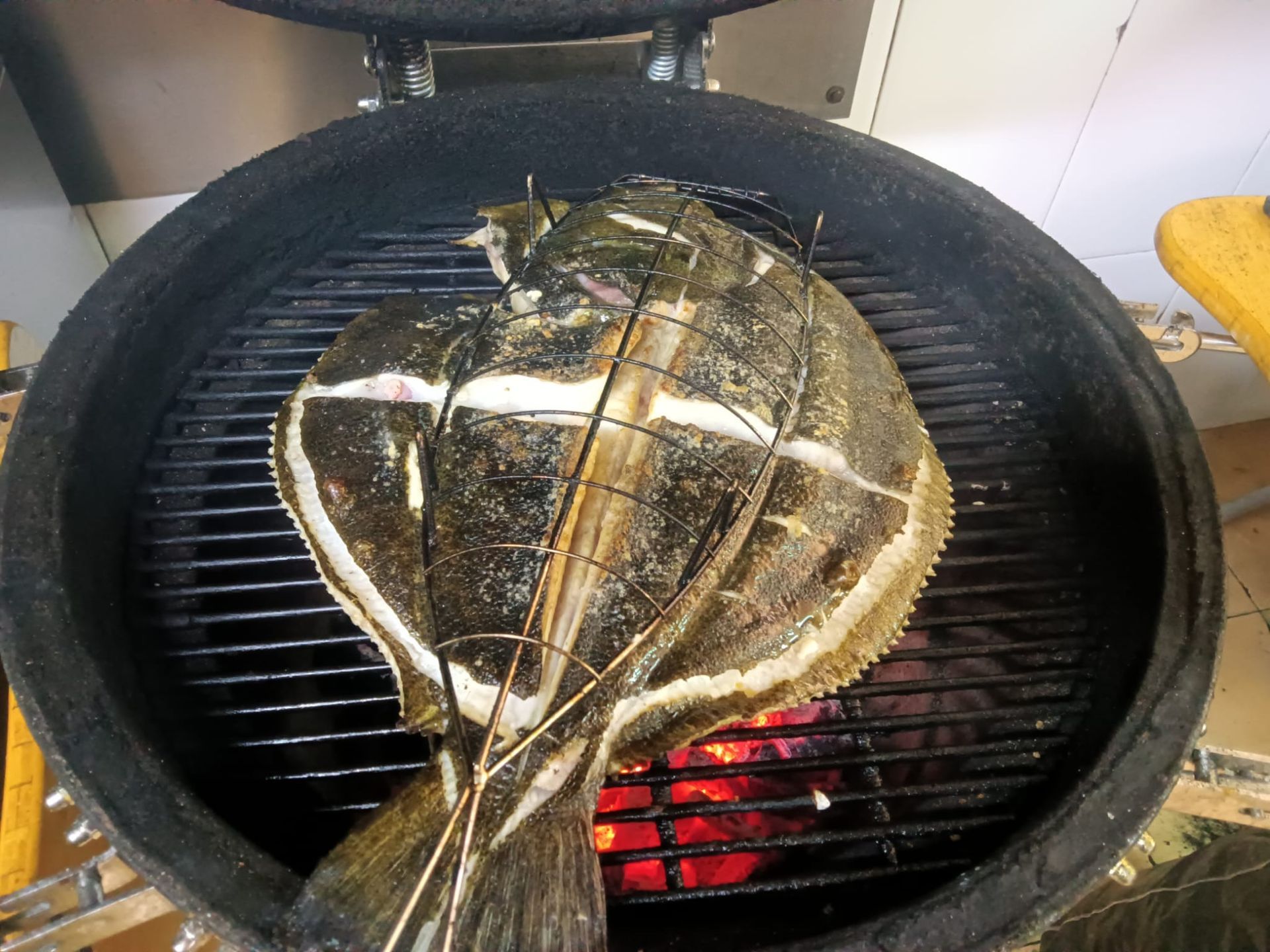 Se está cocinando un pez grande en una parrilla.