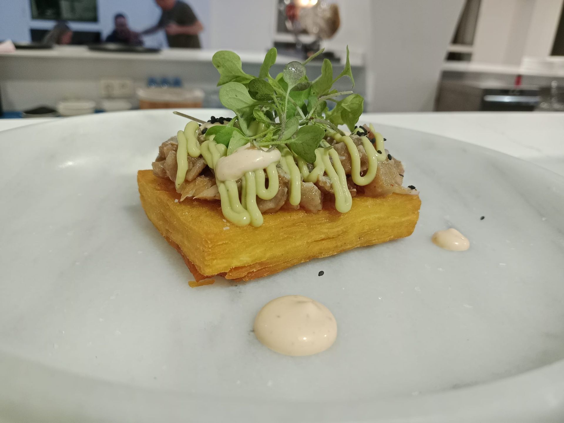 Un plato blanco cubierto con un trozo de comida y salsa.