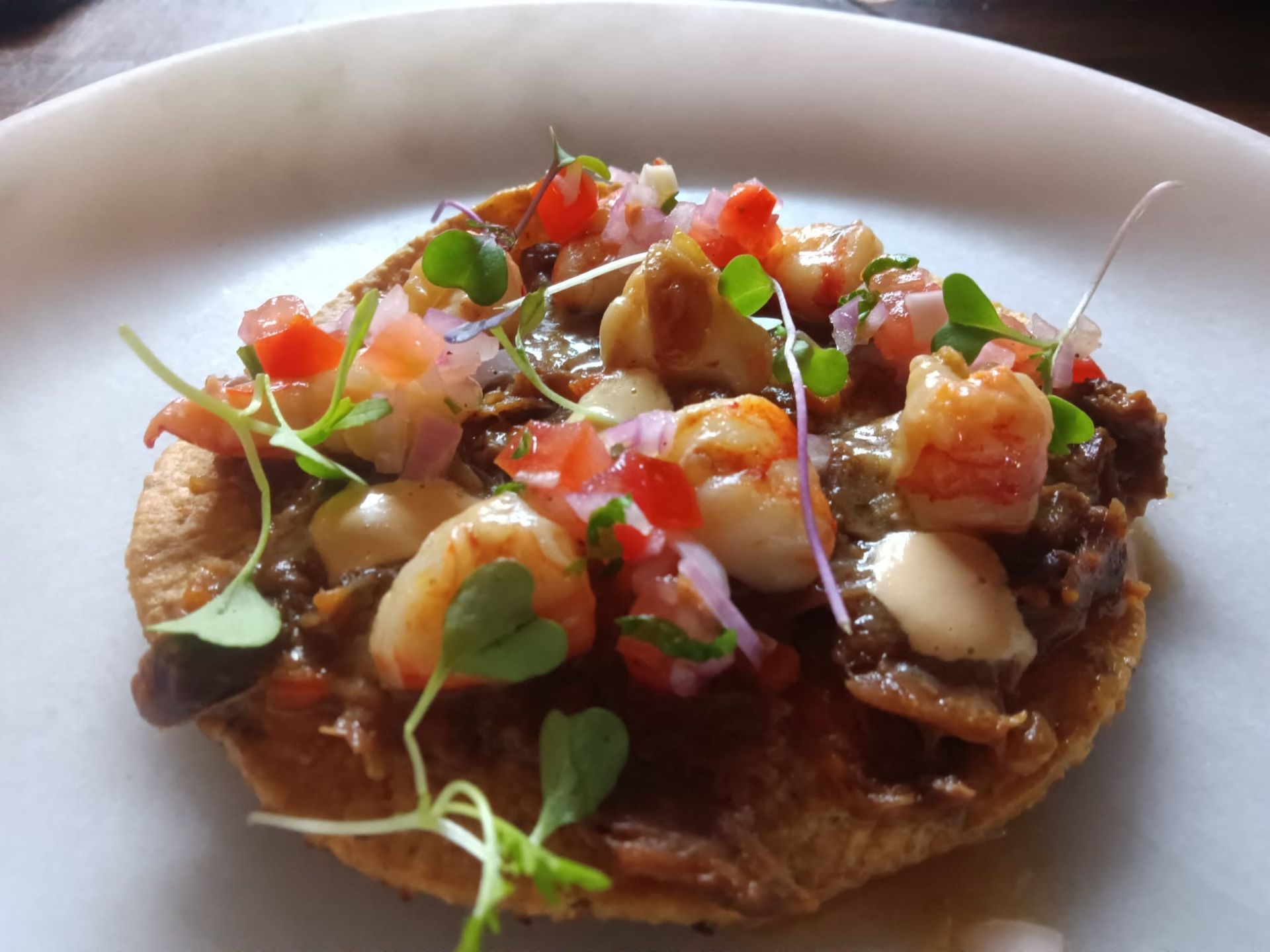 Un primer plano de un plato de comida con camarones y tomates.
