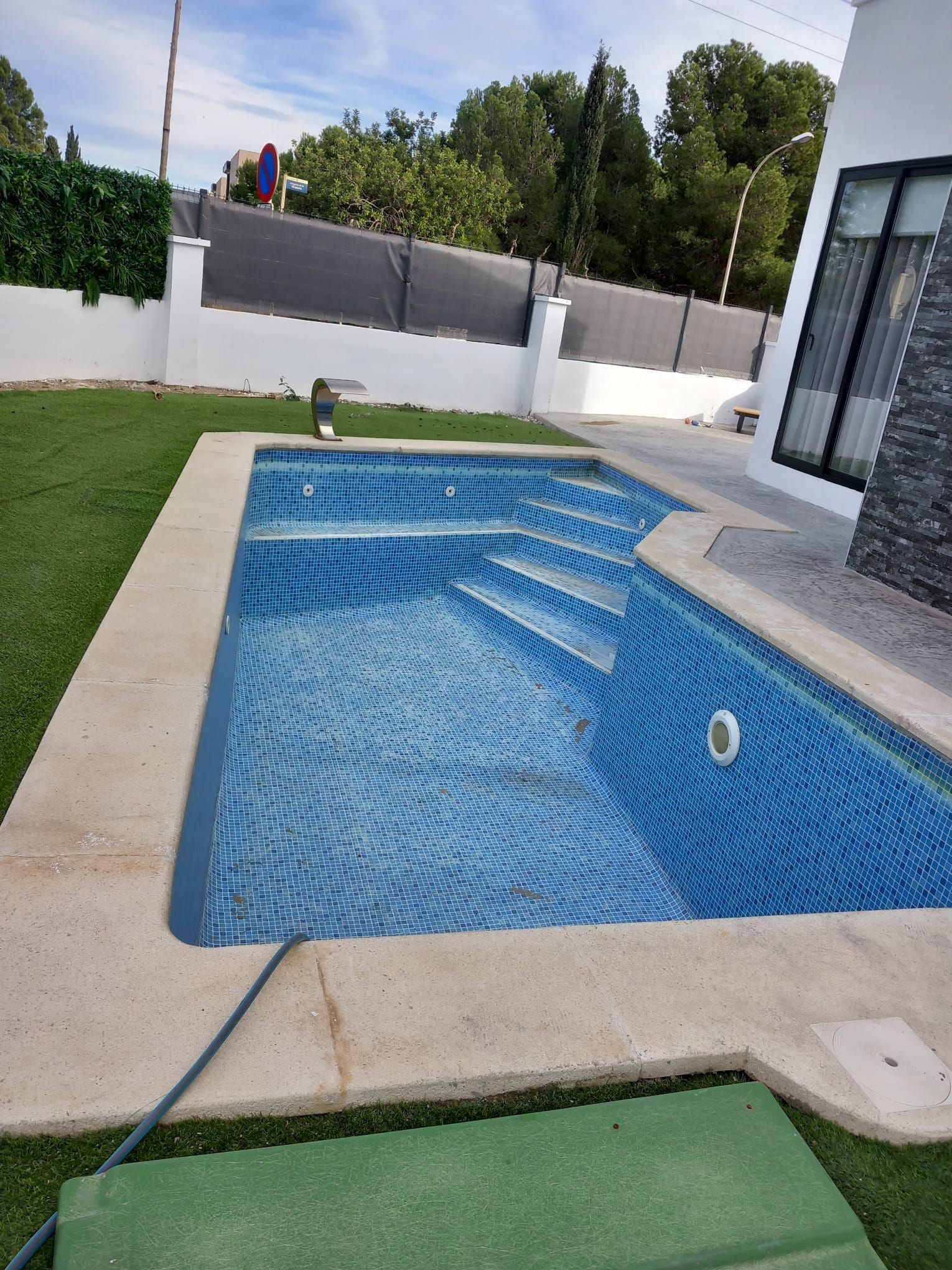 Una gran piscina en el patio trasero de una casa.