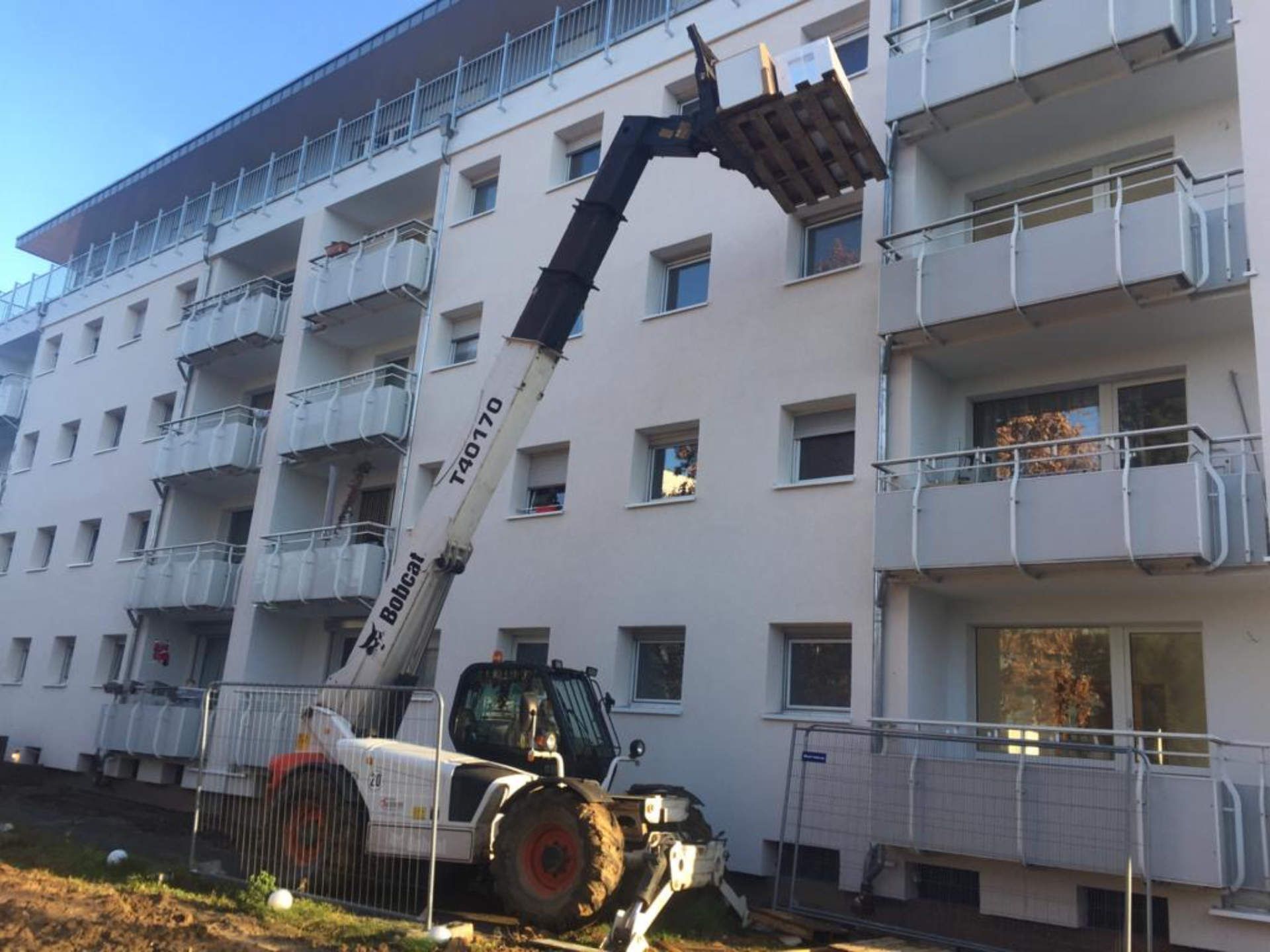 Vor einem Gebäude steht eine Planierraupe.