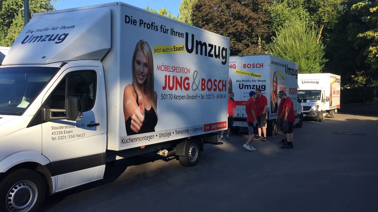 Eine Gruppe Umzugswagen steht auf einem Parkplatz.