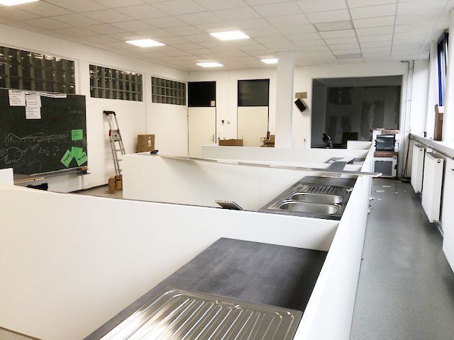 Ein Klassenzimmer mit einer Tafel, auf der „Klassenzimmer“ steht