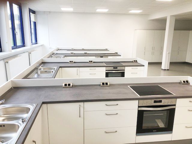 Eine Küche mit weißen Schränken und einem Herd mit Backofen