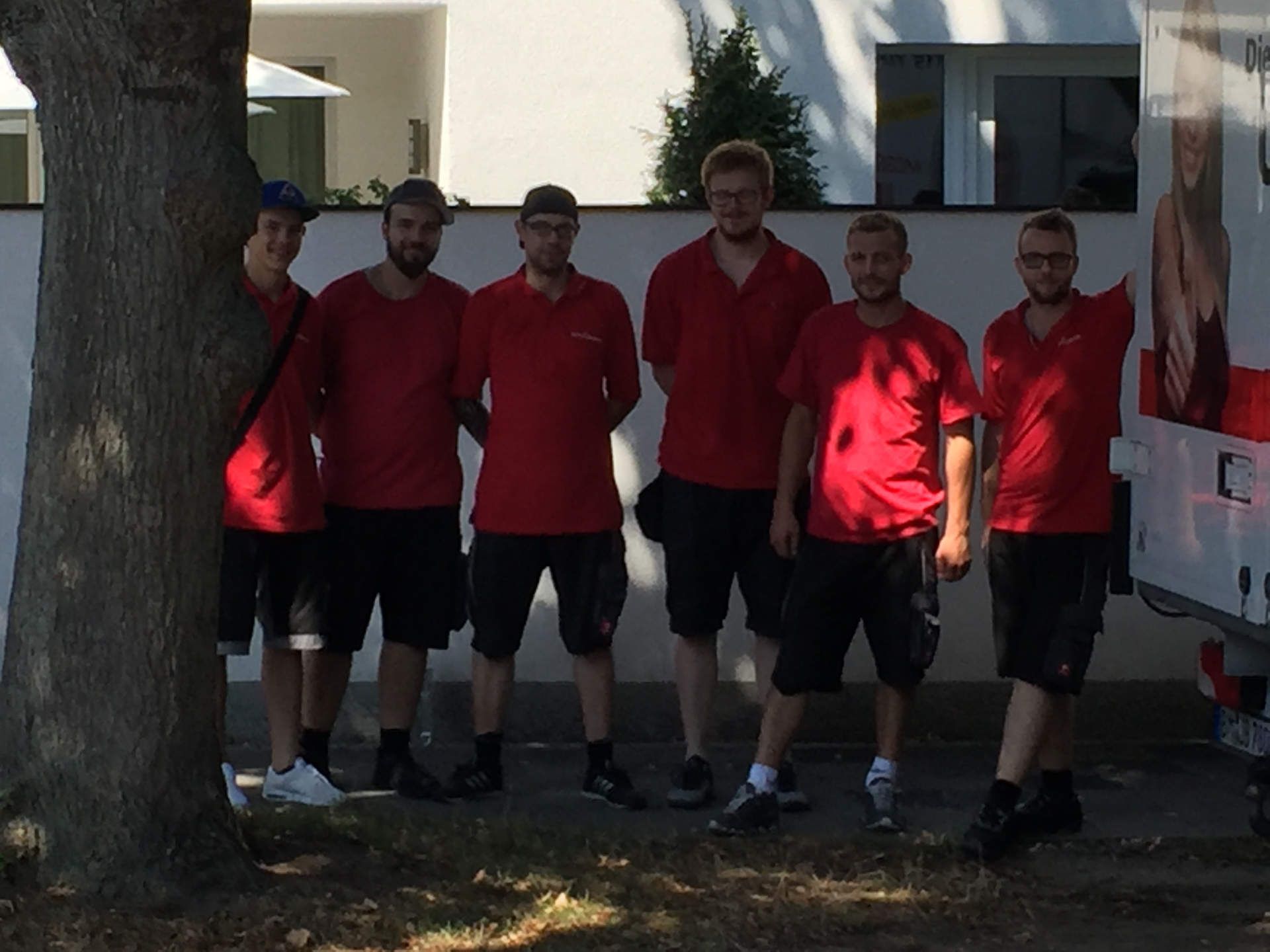 Eine Gruppe von Männern in roten Hemden posiert für ein Foto