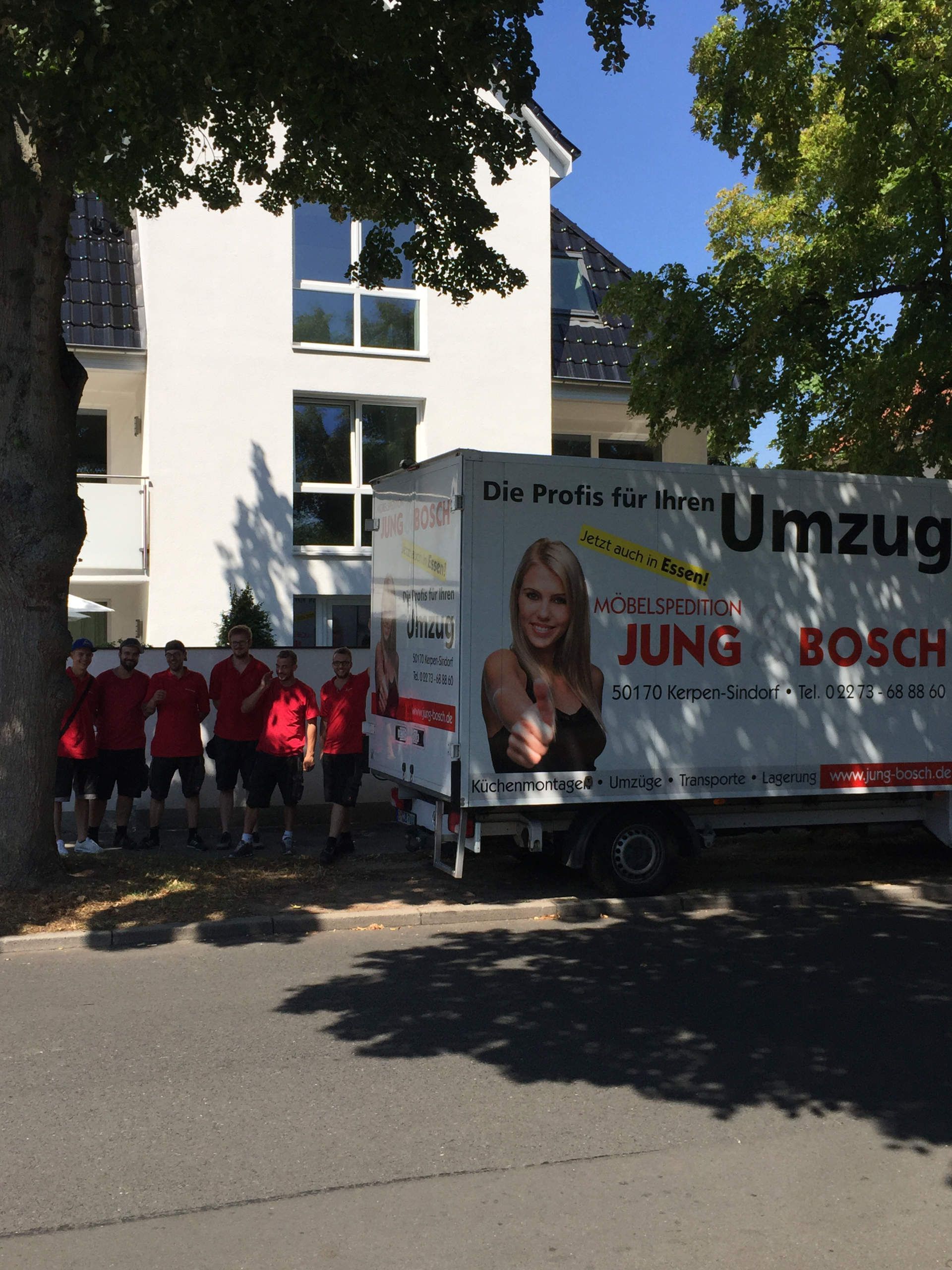 Eine Gruppe von Menschen steht vor einem LKW mit der Aufschrift „Jung Bosch“