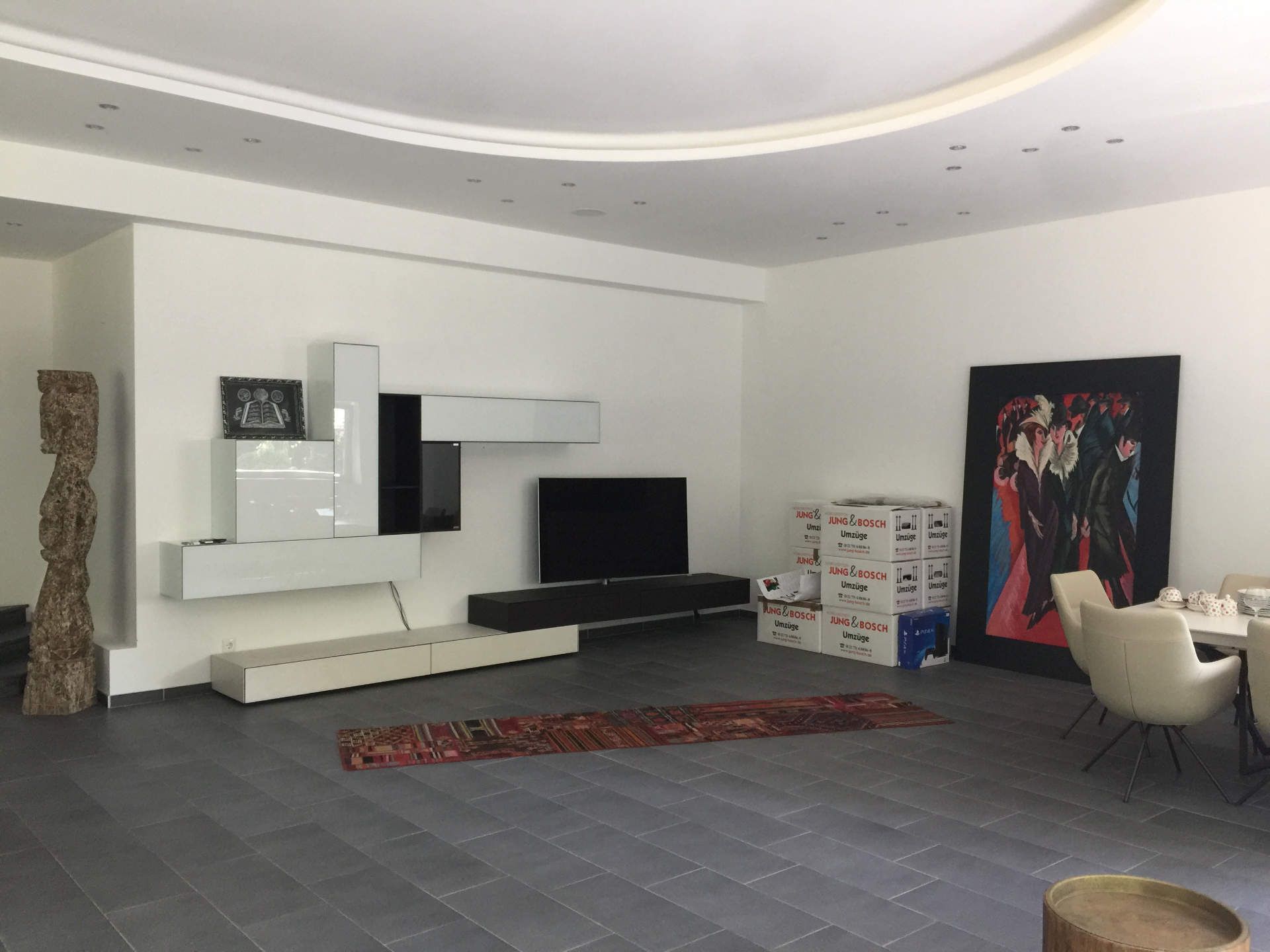 Ein Wohnzimmer mit einem Flachbildfernseher und einem Gemälde an der Wand