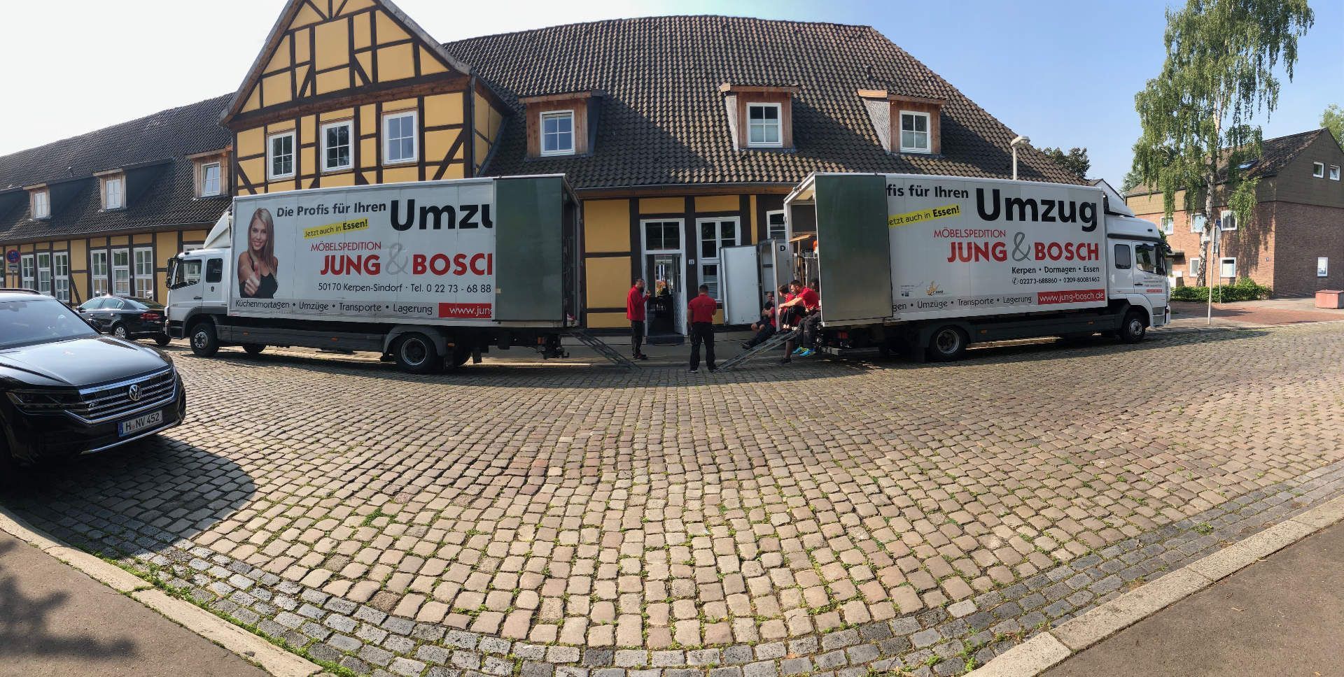 Zwei Umzug-LKW stehen vor einem Gebäude