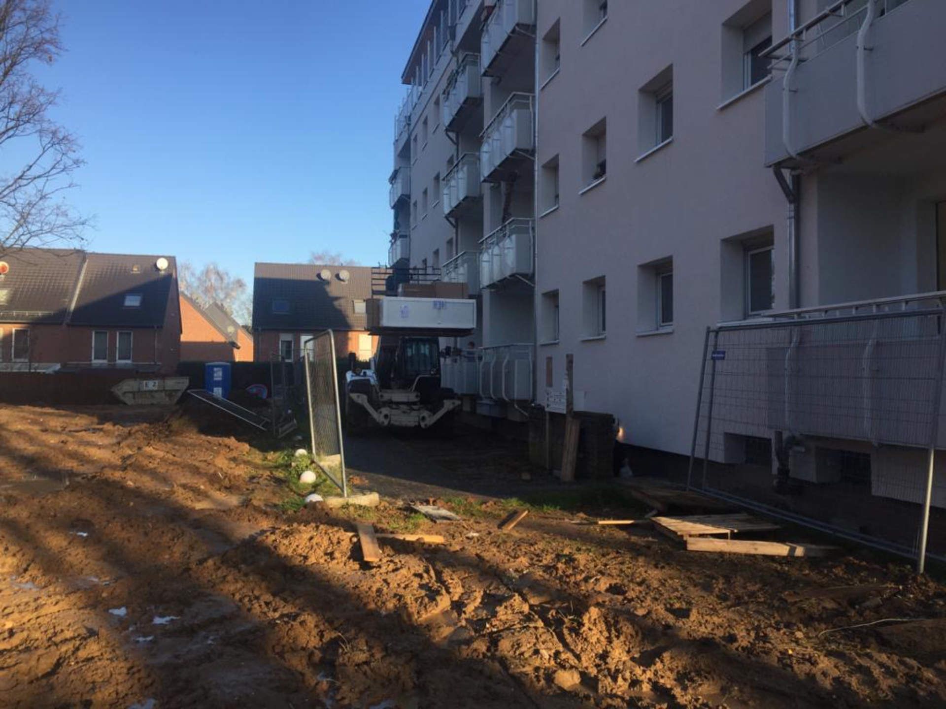 Ein im Bau befindliches Gebäude mit viel Erde davor.