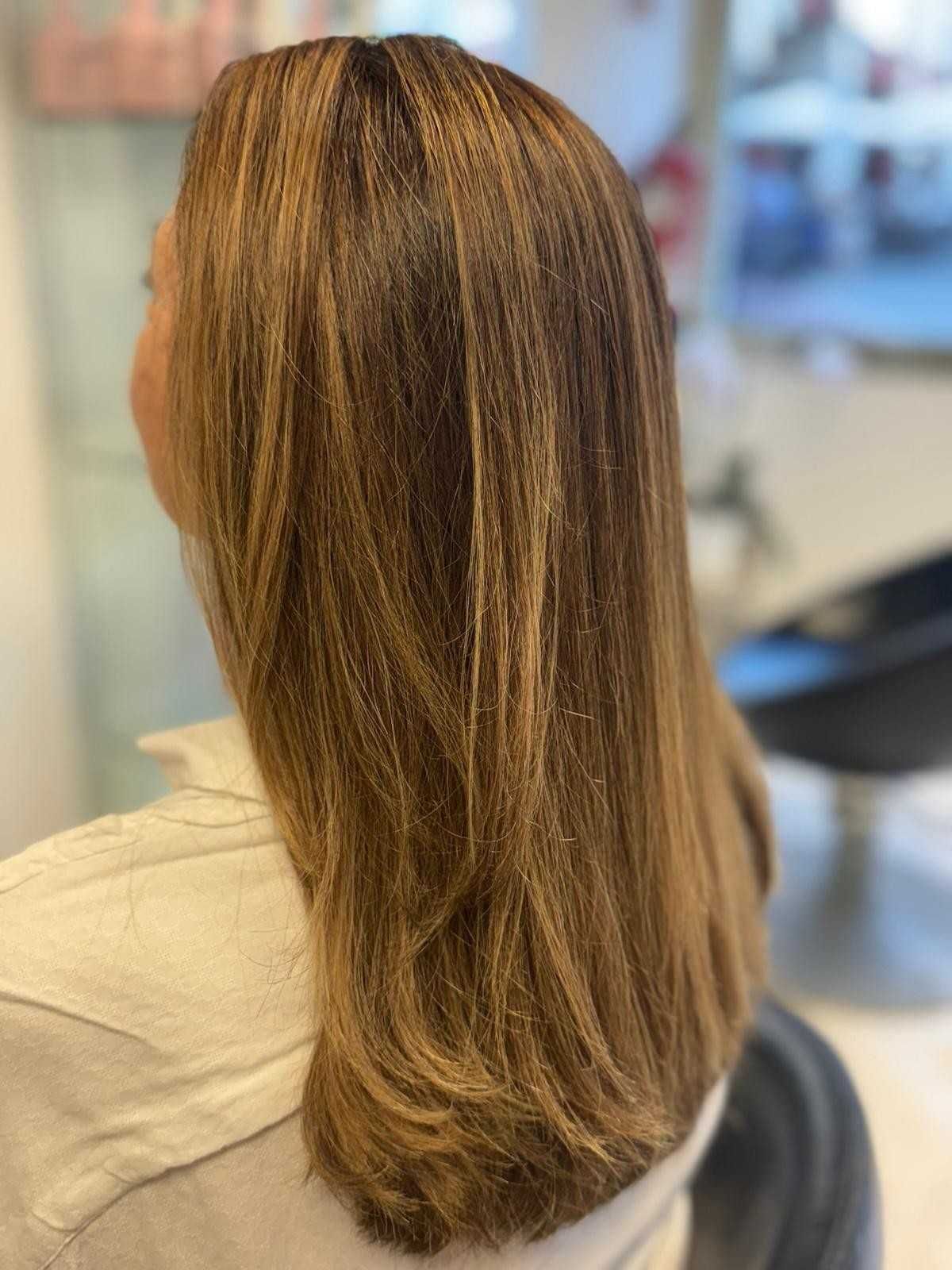 Cabello largo castaño con sutiles reflejos rubios.