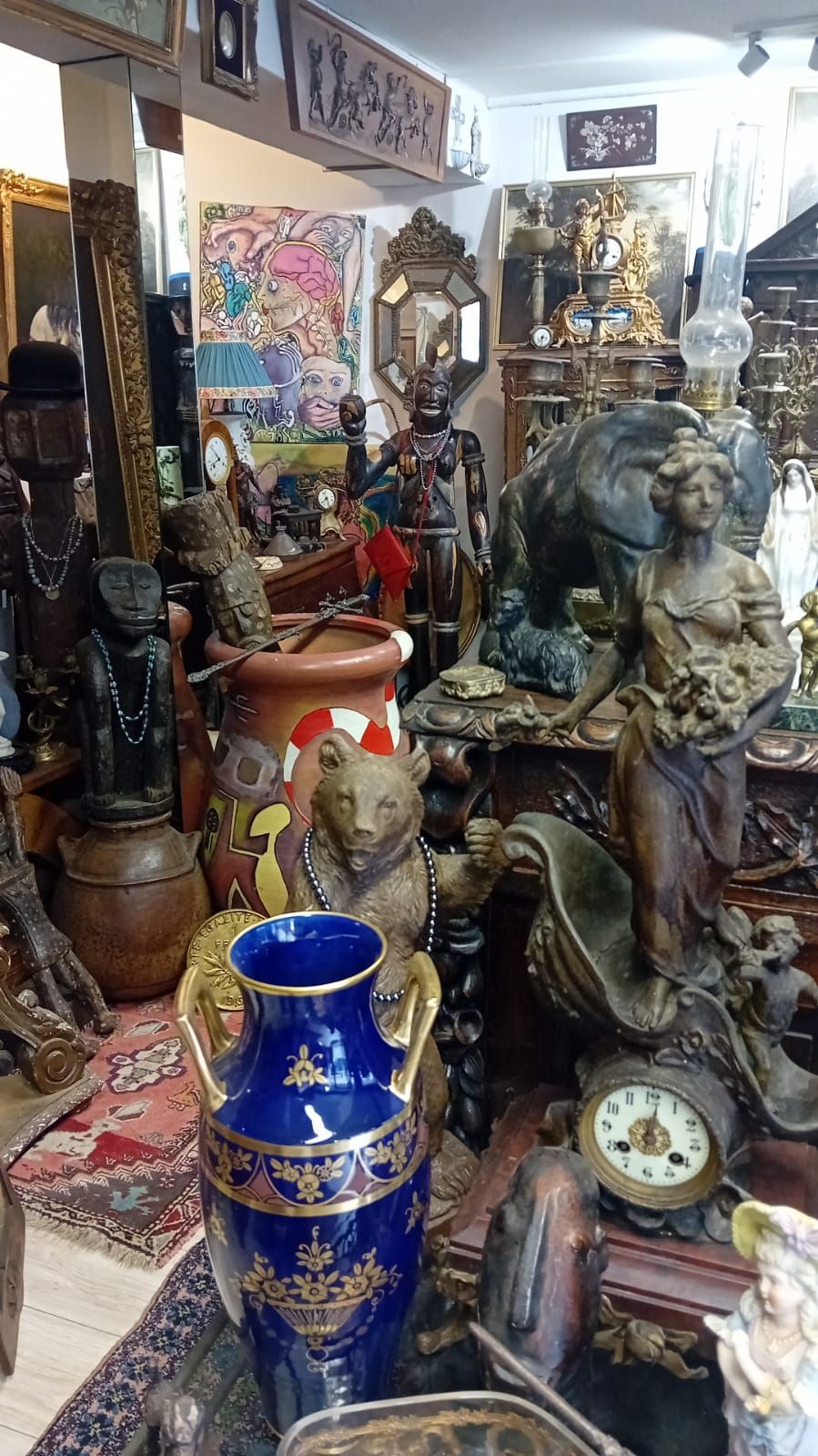 Une boutique d'antiquités encombrée, remplie de sculptures, de vases et d'objets de décoration ornementaux divers.