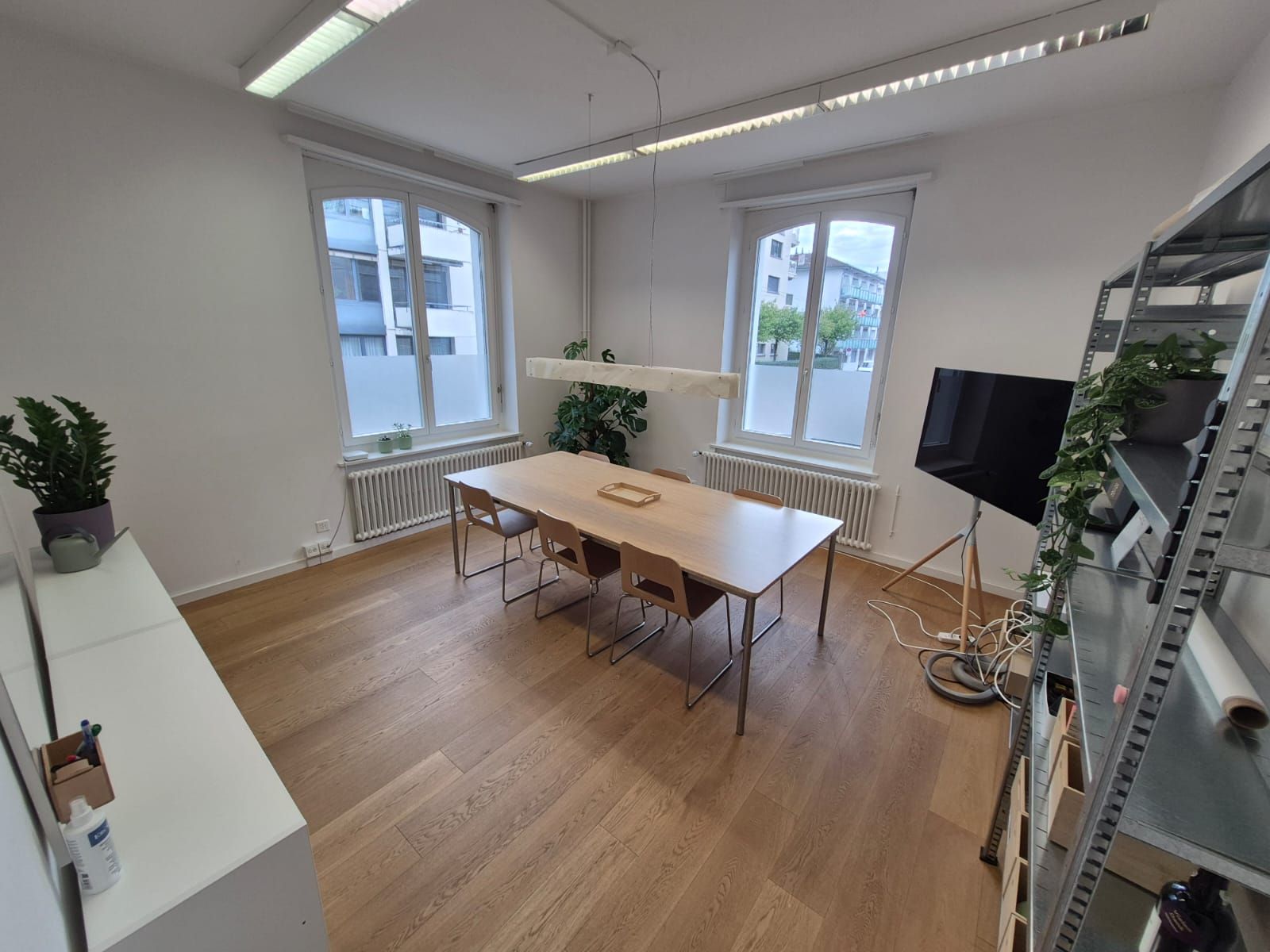 Gebäude mit rot-weisser Fassade, Schild „Wirtschaft zur Burg“, üppiges Grün über der Treppe und rund um den Gebäudeeingang.