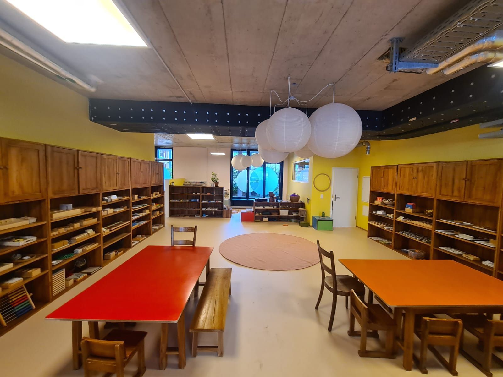 Küche mit weissen Schränken, dunkler Arbeitsplatte und eingebautem schwarzem Backofen, der den Raum reflektiert.