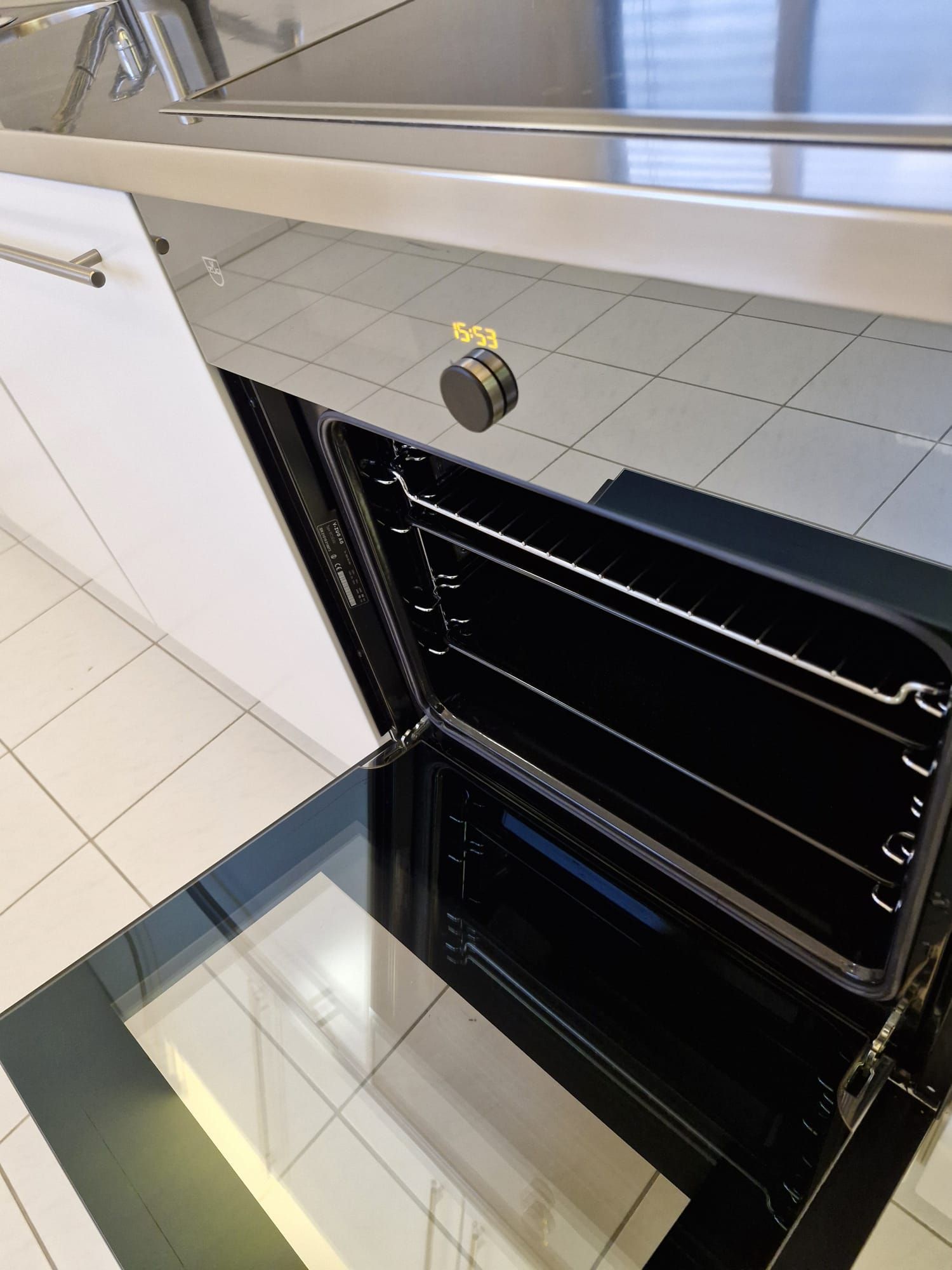 Modernes Wohnzimmer mit dunklem Fliesenboden, grossen Fenstern und zeitgenössischen Möbeln.