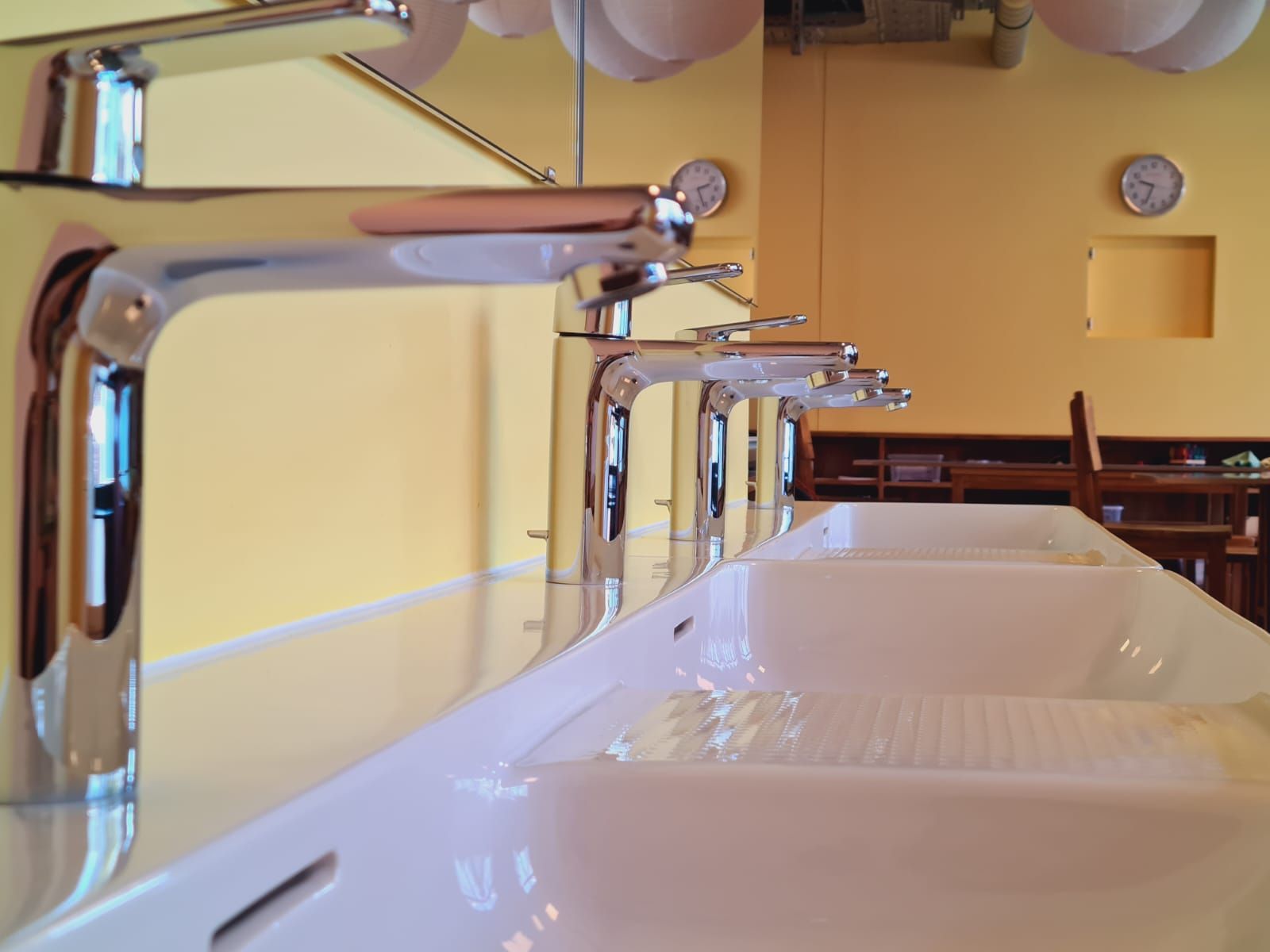 Modernes Wohnzimmer mit dunklem Fliesenboden, grossen Fenstern und zeitgenössischen Möbeln.