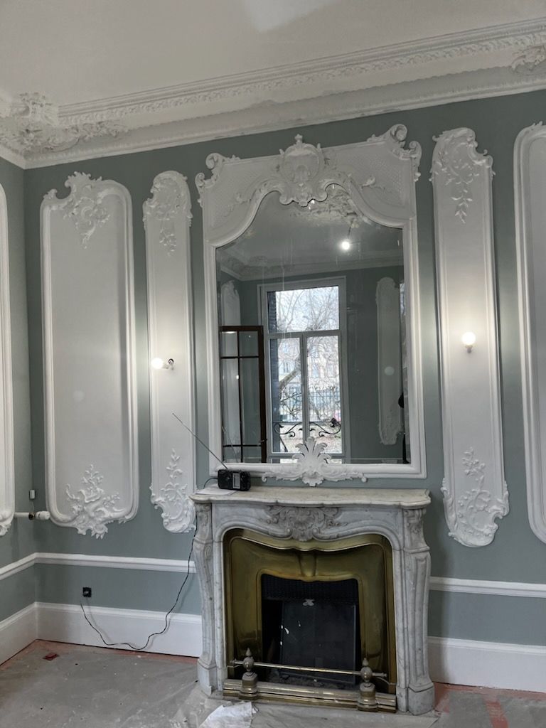 Pots de peinture, pinceau, échantillons de couleurs et plans sur une surface en bois, prêts pour un projet de bricolage.