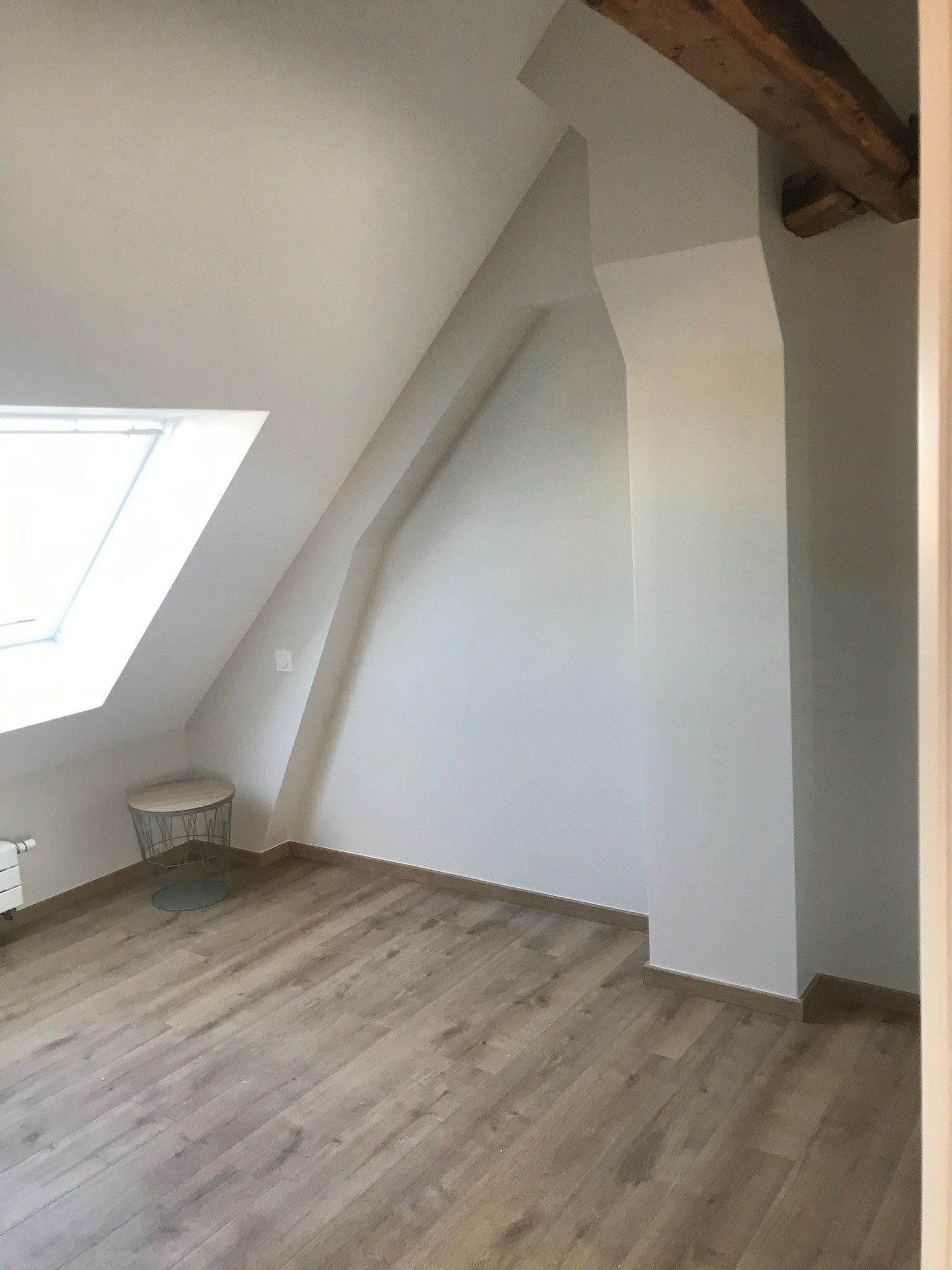 Personne posant un parquet en bois gris foncé.