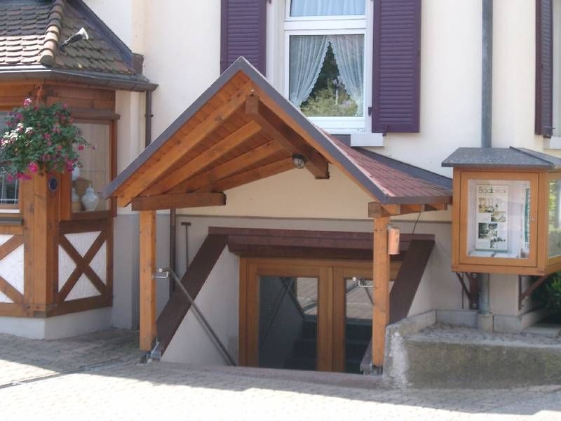 Ein Gebäude mit einer hölzernen Veranda und einem Schild mit der Aufschrift „a“ darauf