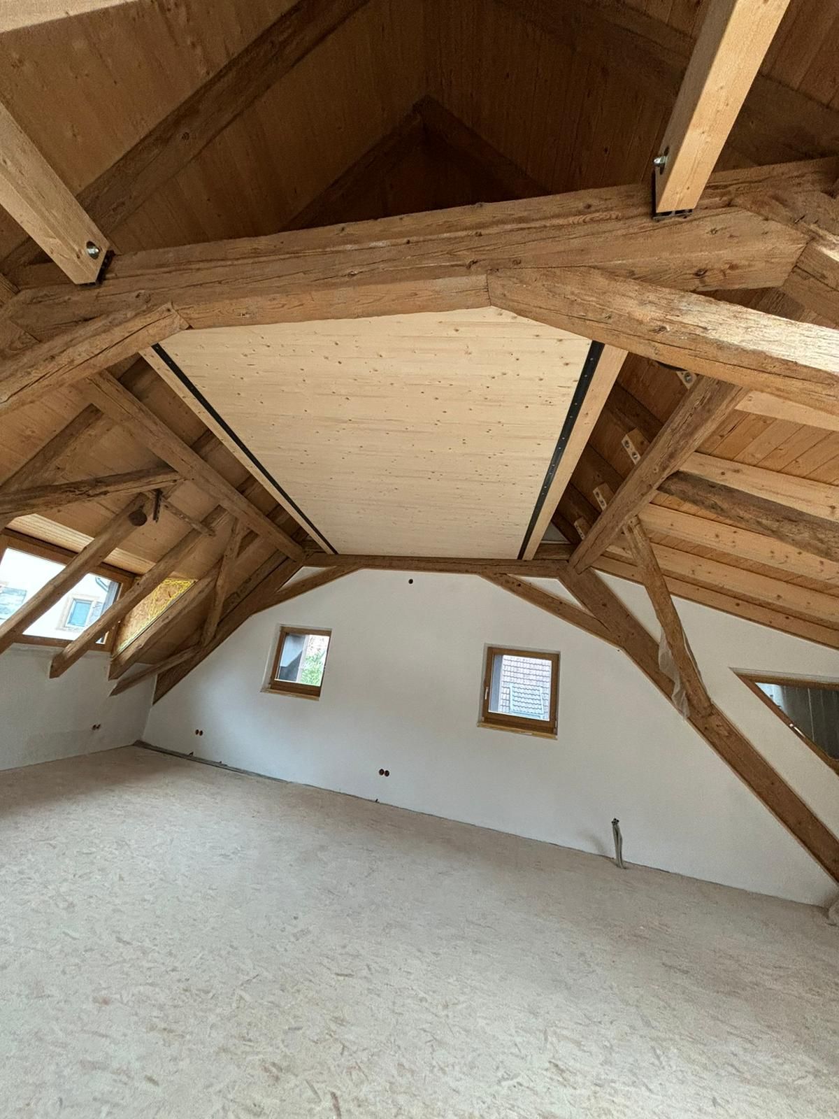 Ein Raum mit Holzdecke und wenigen Fenstern