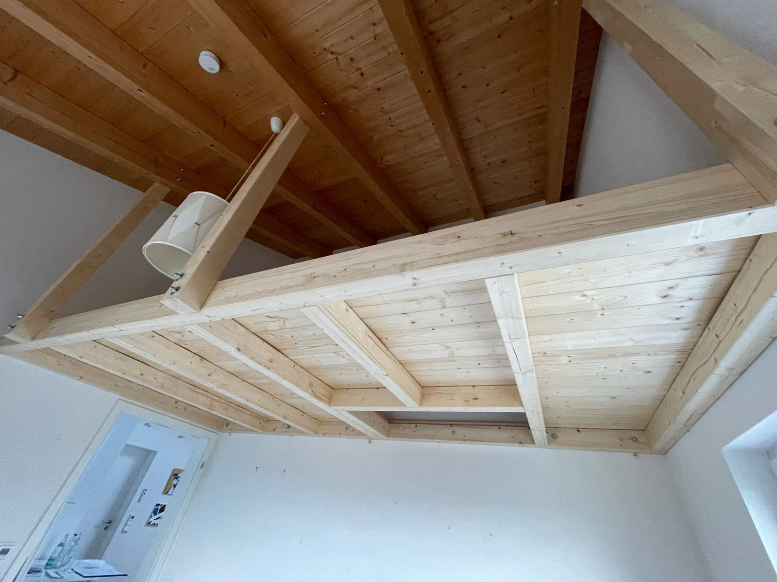 Eine Holzdecke in einem Raum mit einer Lampe darauf