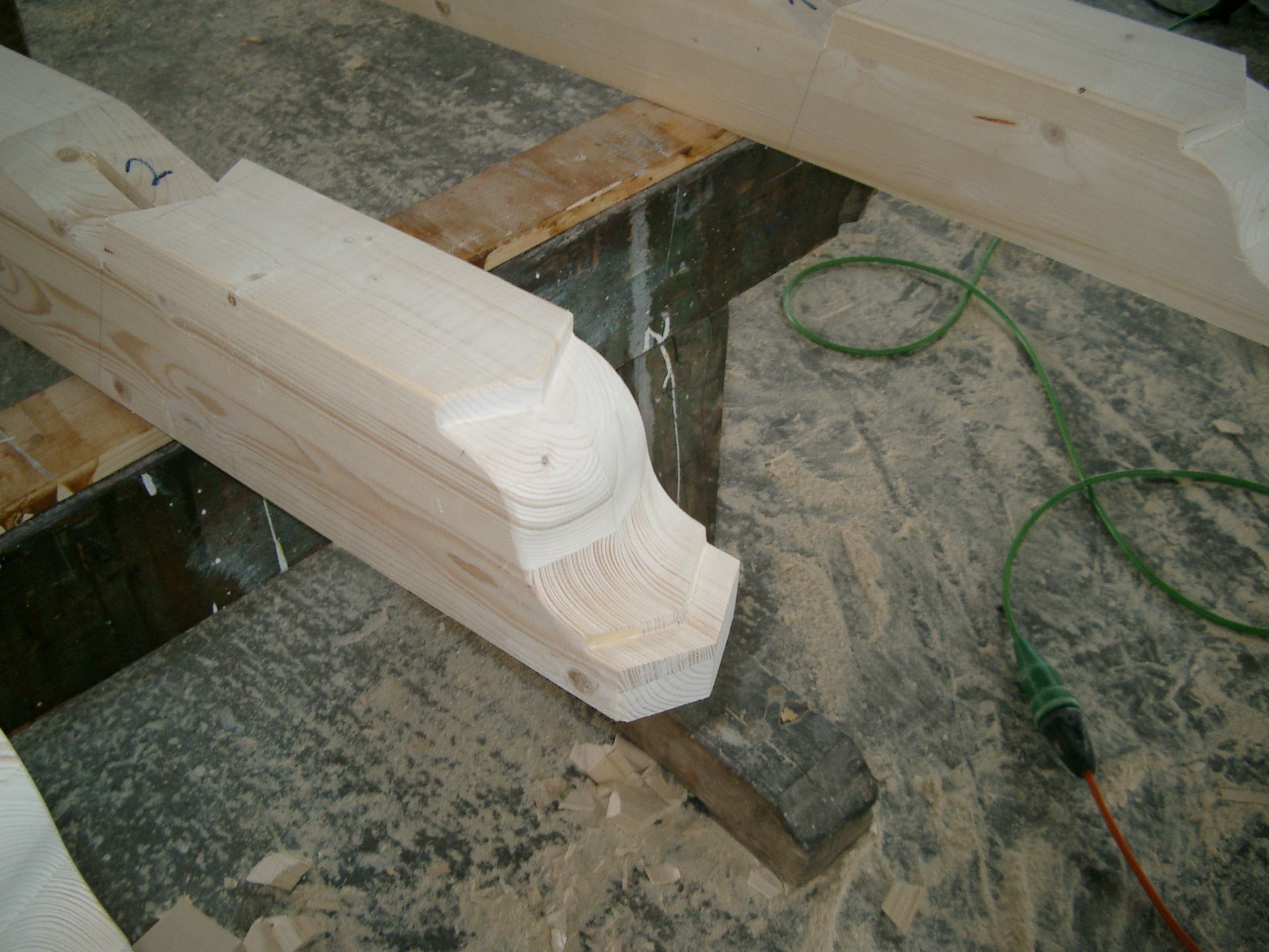 Auf einem Tisch liegt ein Stück Holz neben einer grünen Schnur.