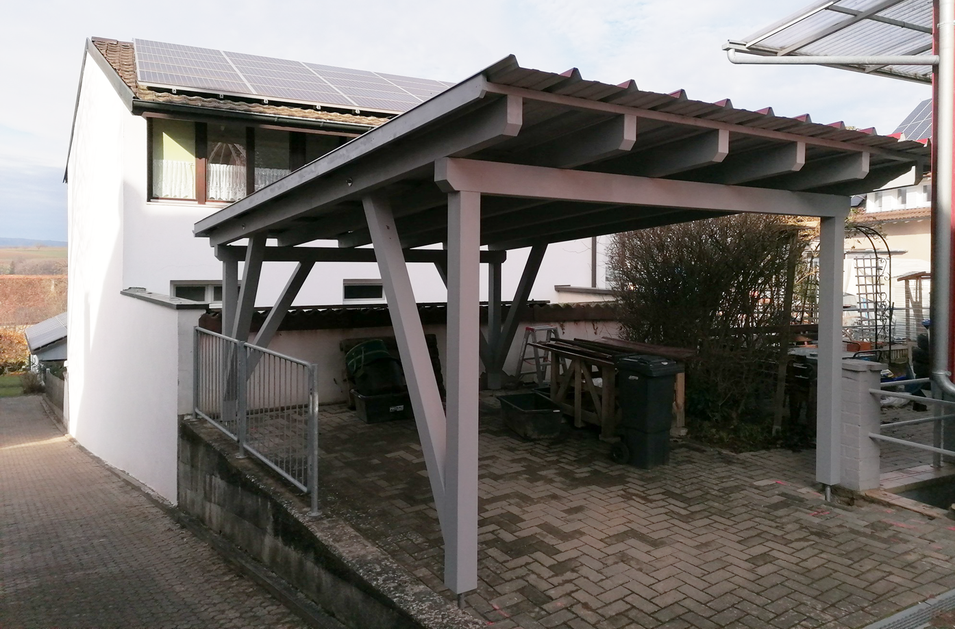 Ein weißes Haus mit einem Carport davor
