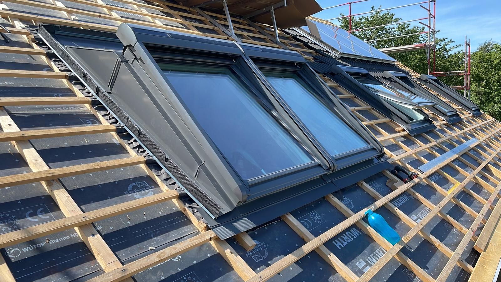 Ein Dach mit vielen Fenstern und Solarzellen darauf.