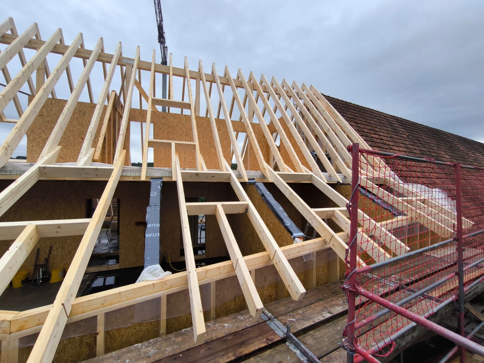 Auf einem Gebäude wird eine Holzkonstruktion errichtet.
