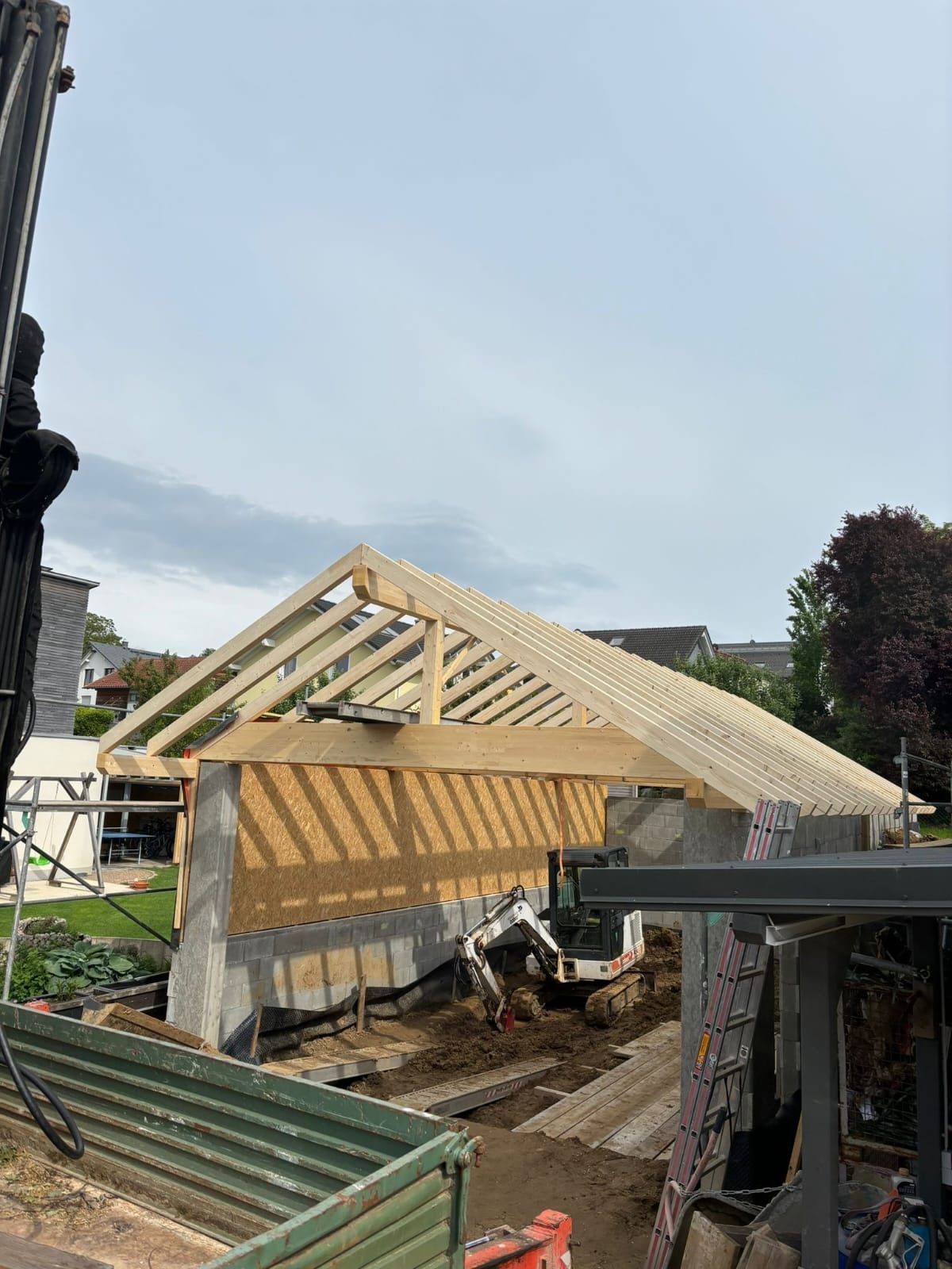 Auf einem Gebäude wird ein großes Holzdach errichtet.