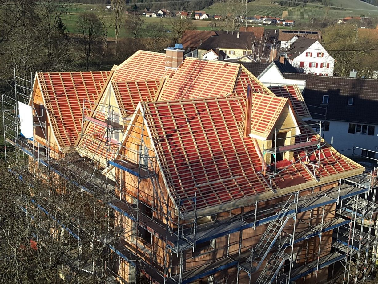 Eine Luftaufnahme eines im Bau befindlichen Hauses mit Gerüst auf dem Dach.