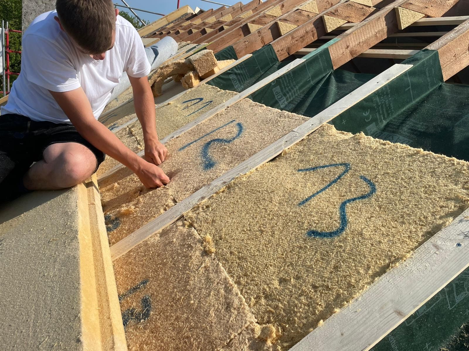 Ein Mann arbeitet auf dem Dach eines Gebäudes.