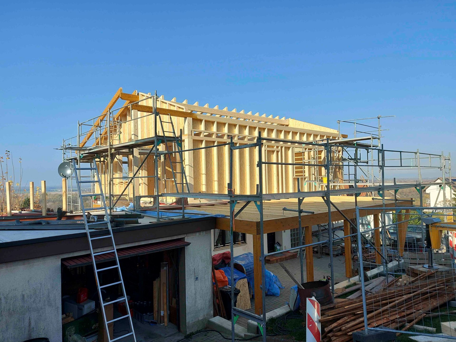 Mit Gerüst und Leiter wird ein Haus gebaut.