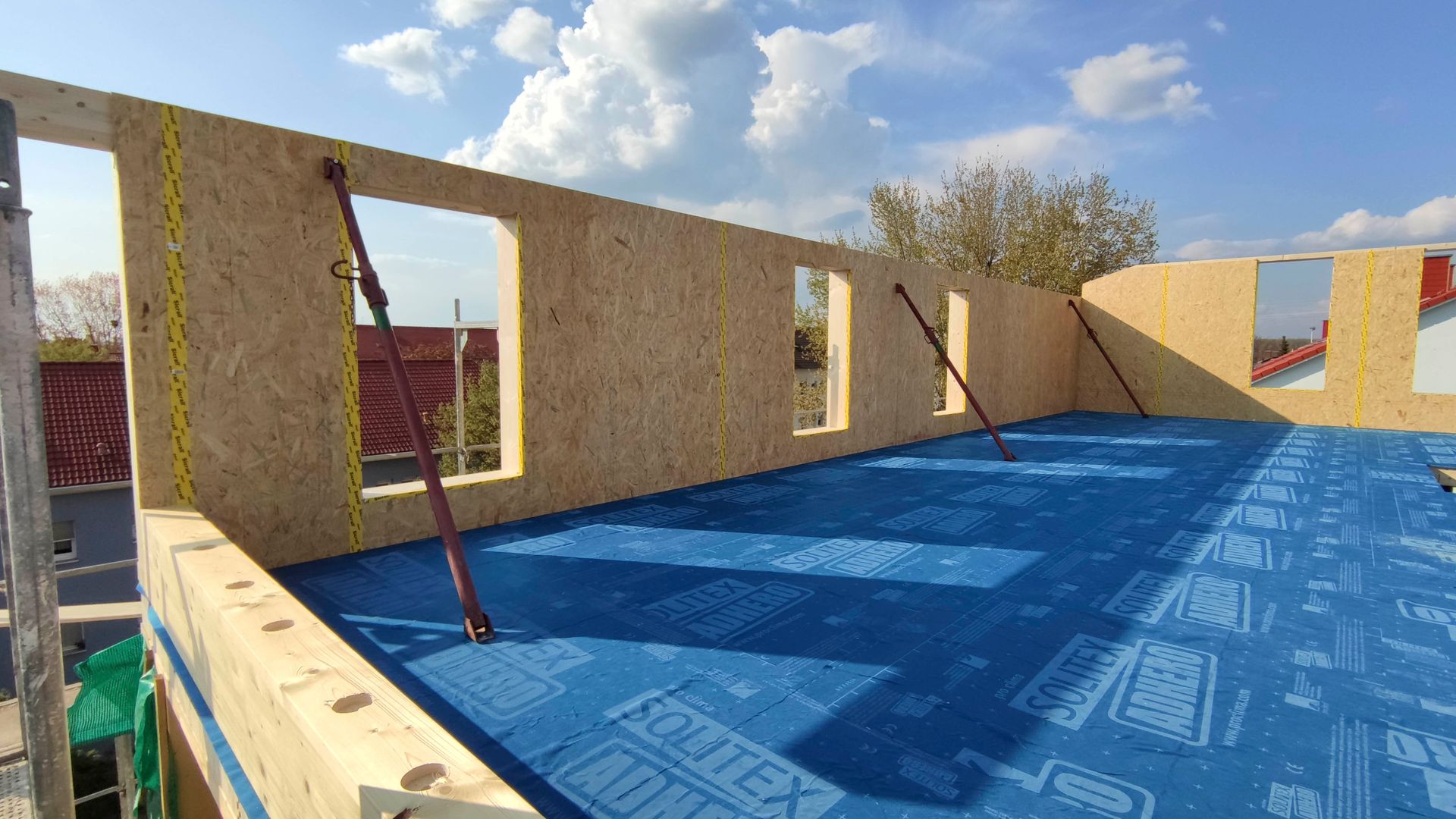 Ein im Bau befindliches Gebäude mit einer blauen Plane auf dem Boden.