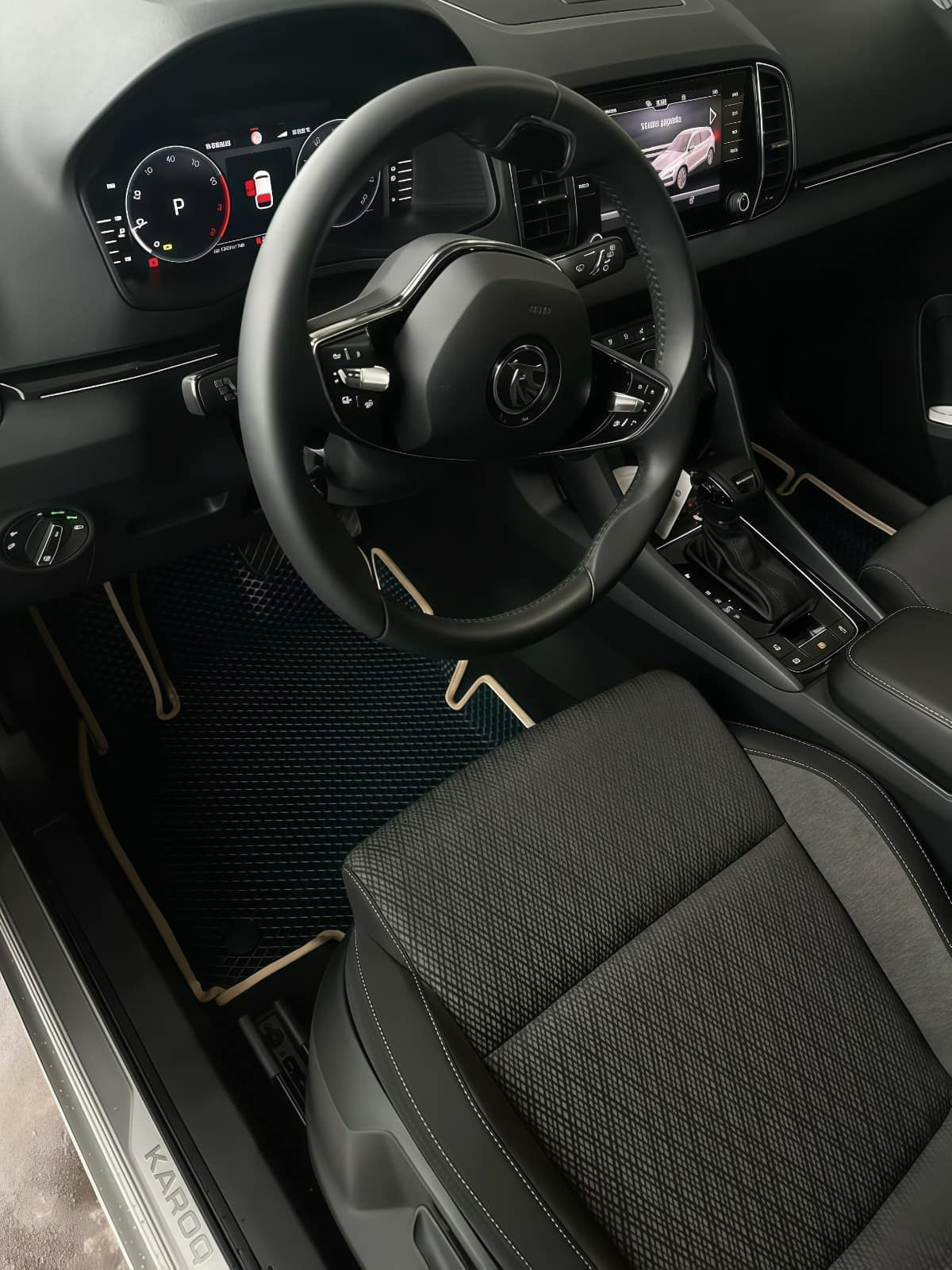 Interior del coche con volante, tablero y asiento texturizado de color negro.