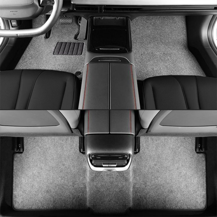 Vista aérea del interior de un automóvil con alfombrillas grises, asientos y consola negros.