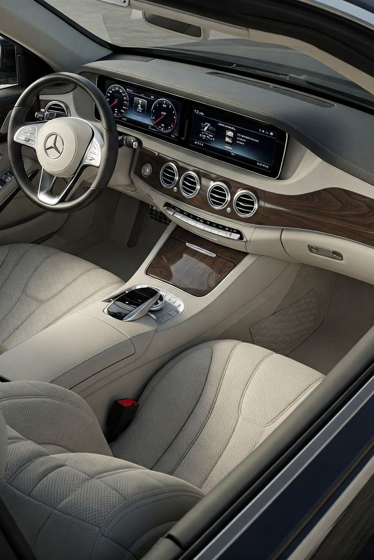 Interior de un Mercedes-Benz convertible de color beige y con detalles de madera, que muestra el tablero, el volante y los asientos.