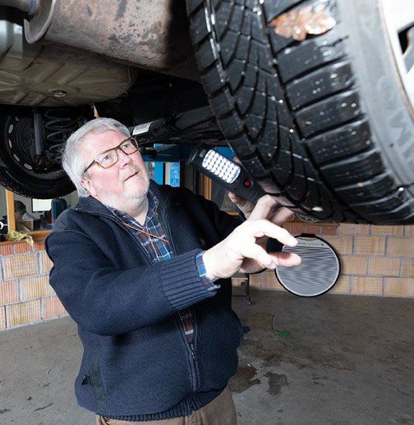 Heinz-Jürgen Petrikowski überprüft Reifen eines Fahrzeuges