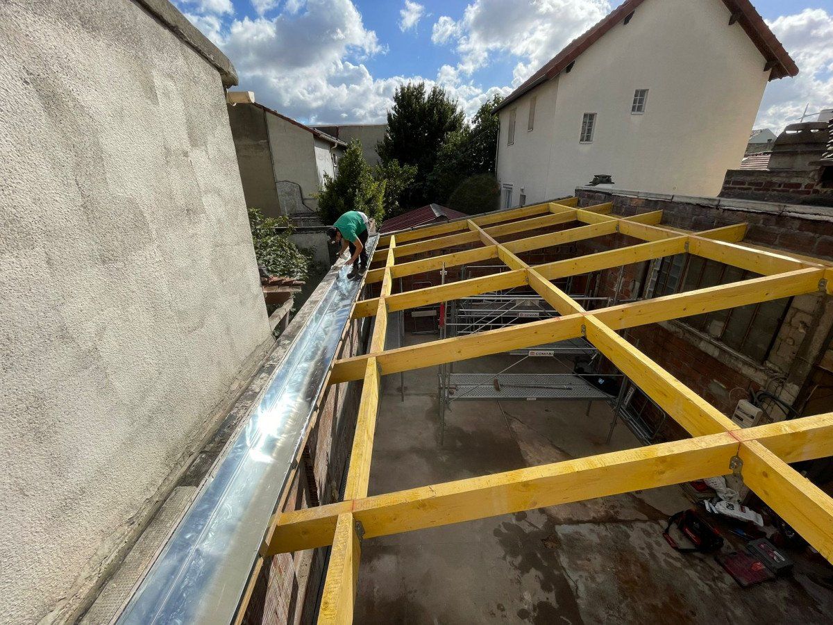 Un homme travaille sur une charpente en construction