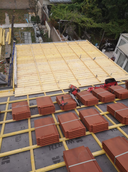 Des tuiles posées sur un toit en travaux