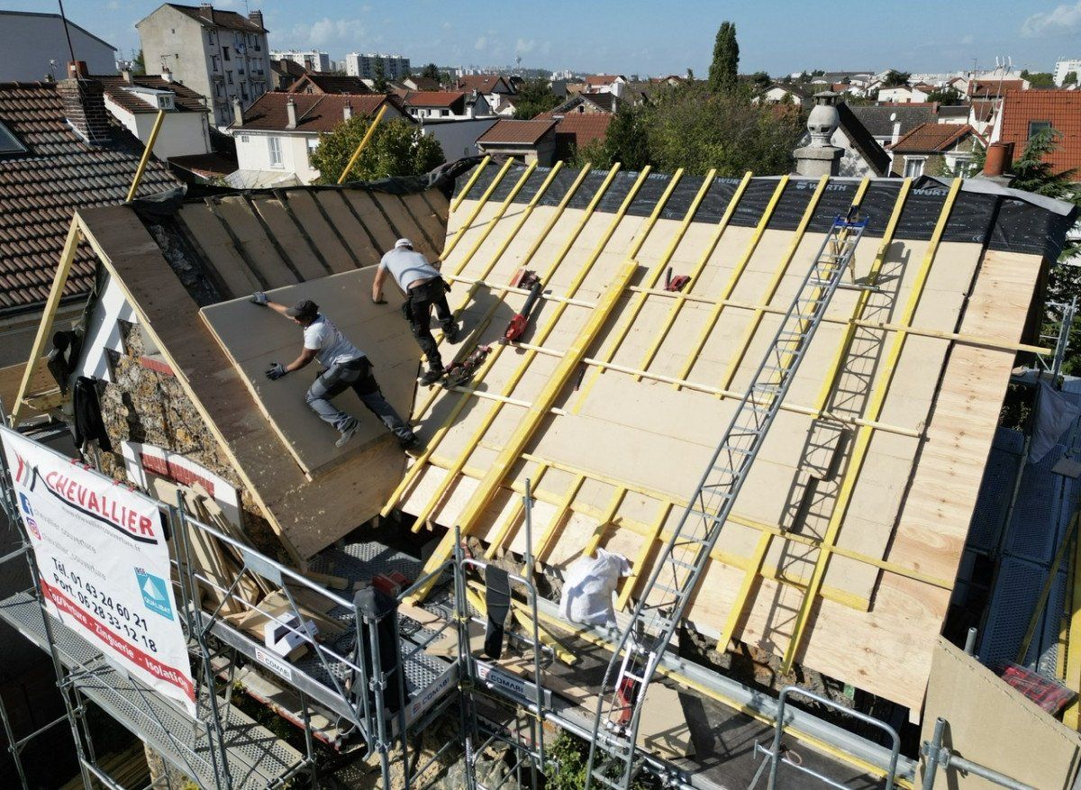 Des ouvriers isolent l'extérieur d'un toit