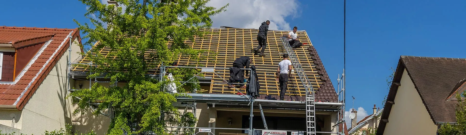 Des hommes sur un toit en travaux